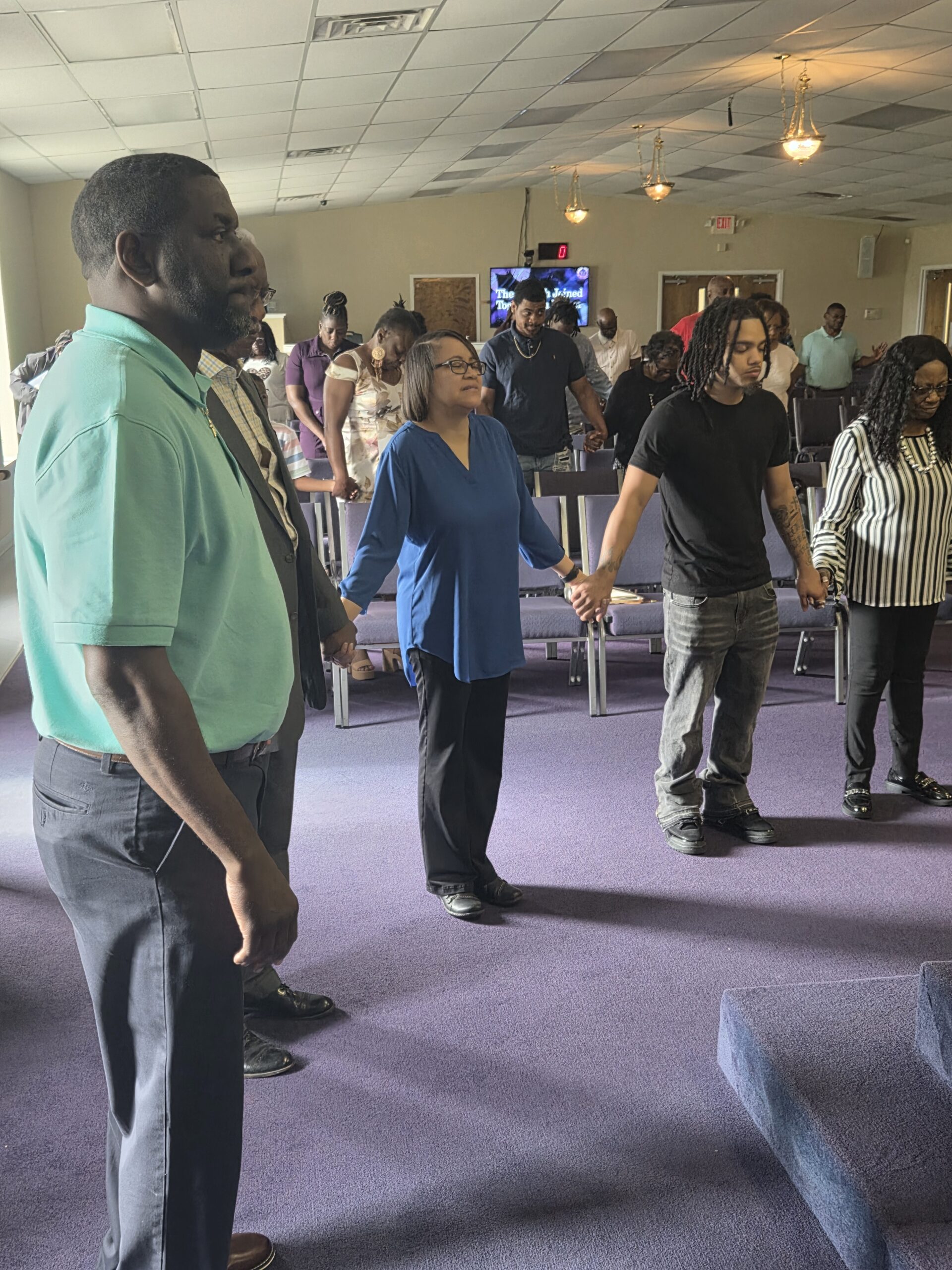 Church family holding hands in prayer